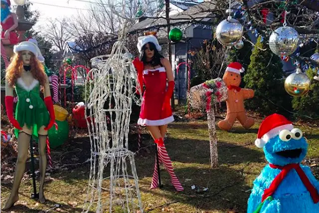 This is a photo of two busty mannequins in Christmas negligees, plus a large Cookie Monster and a bunch of candy canes on a New Jersey lawn.